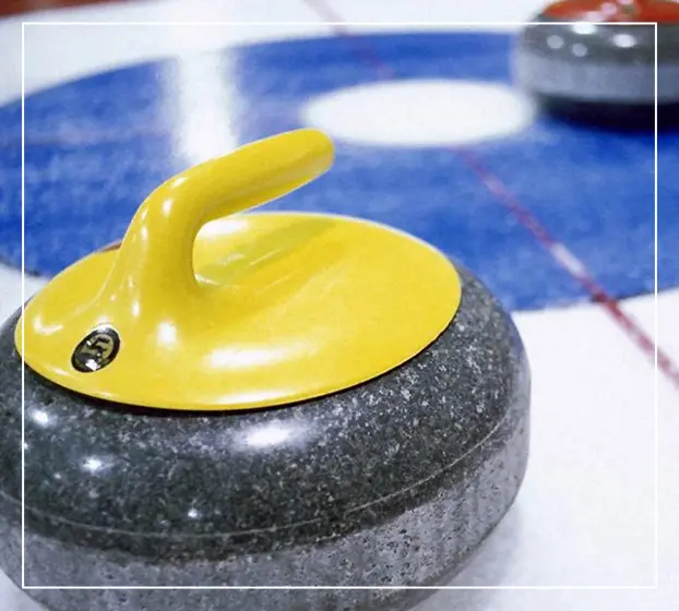 A yellow and black stone on the ice