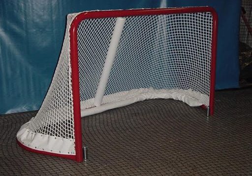 A hockey net on the floor of an indoor rink.
